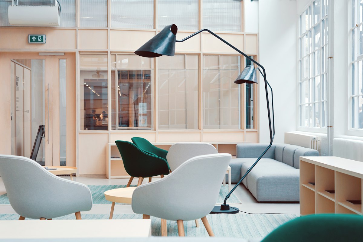 Espace de travail lumineux, avec fauteuils et grande fenêtre.